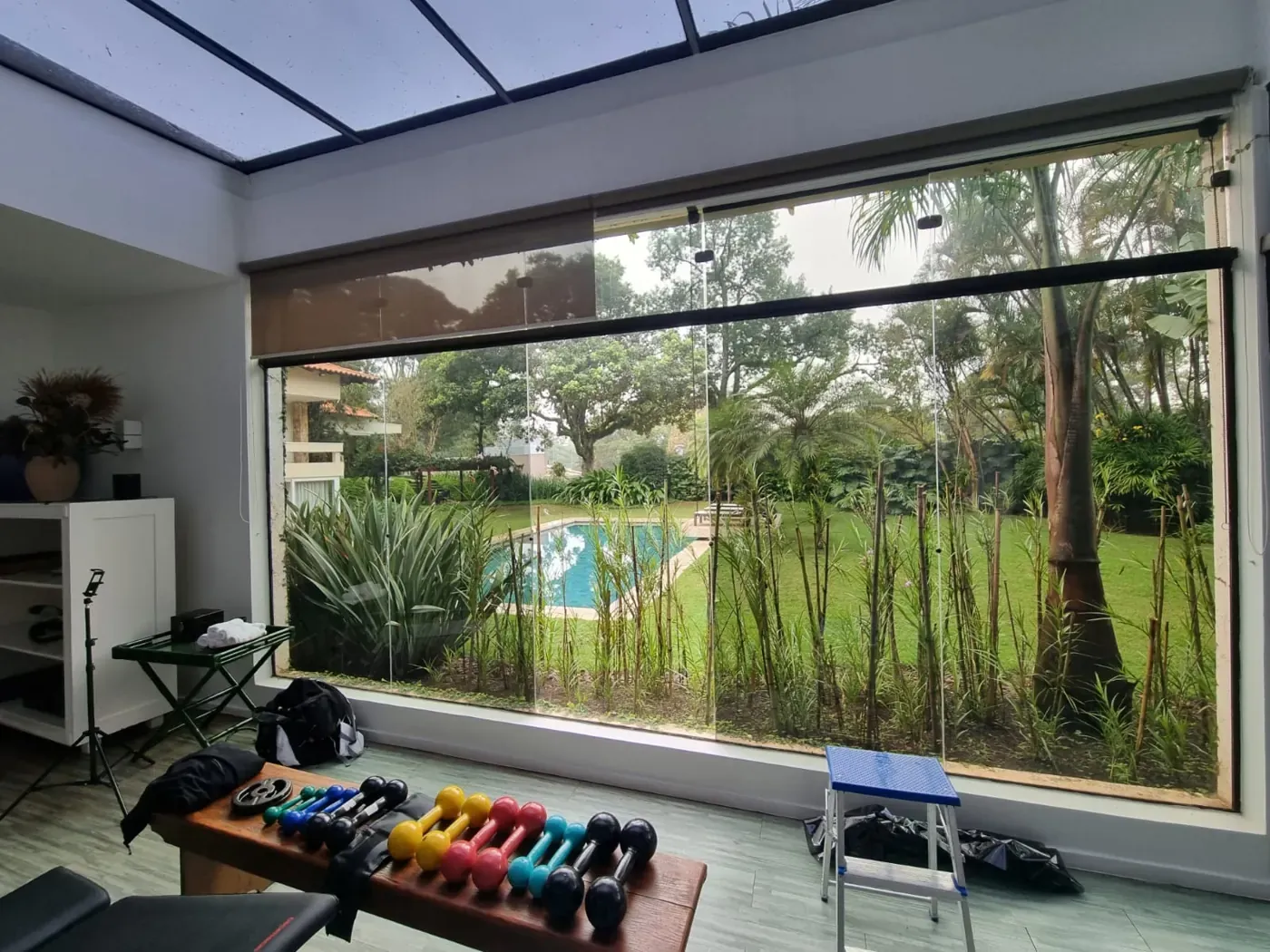 Academia com parede de vidro e película nanocerâmica, vista para a piscina